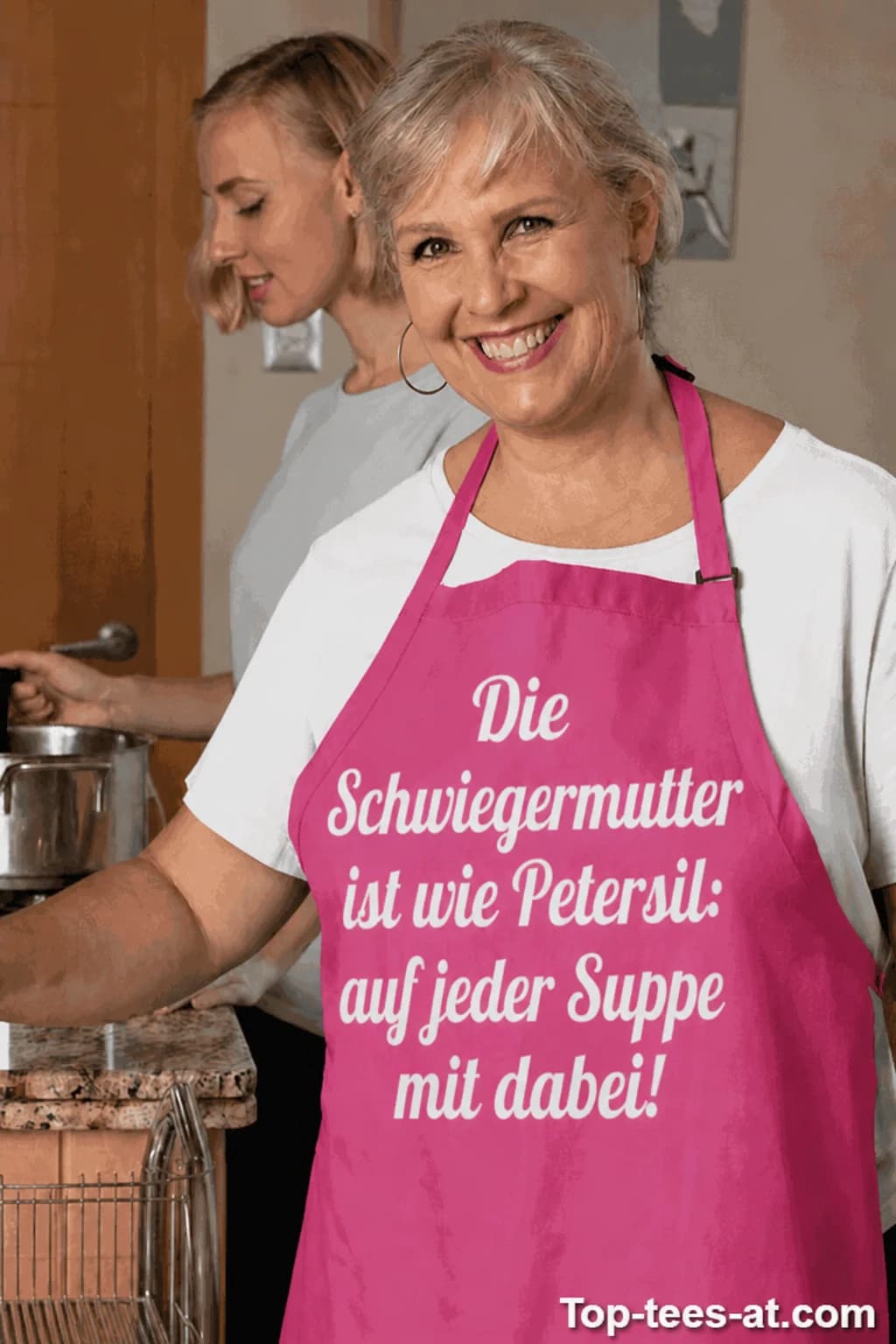 Schwiegermutter in pinker Schürze mit Spruch „Die Schwiegermutter ist wie Petersil: auf jeder Suppe mit dabei!“