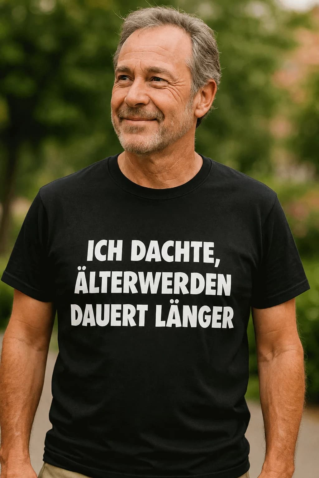 Älterer Mann im schwarzen T-Shirt mit weißem Spruch „Ich dachte, Älterwerden dauert länger“